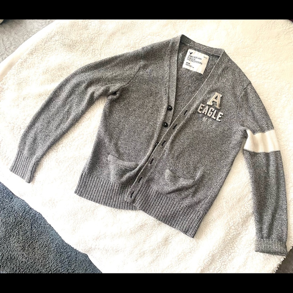 Cardigan sweater medium grey with white trim on sleeves.